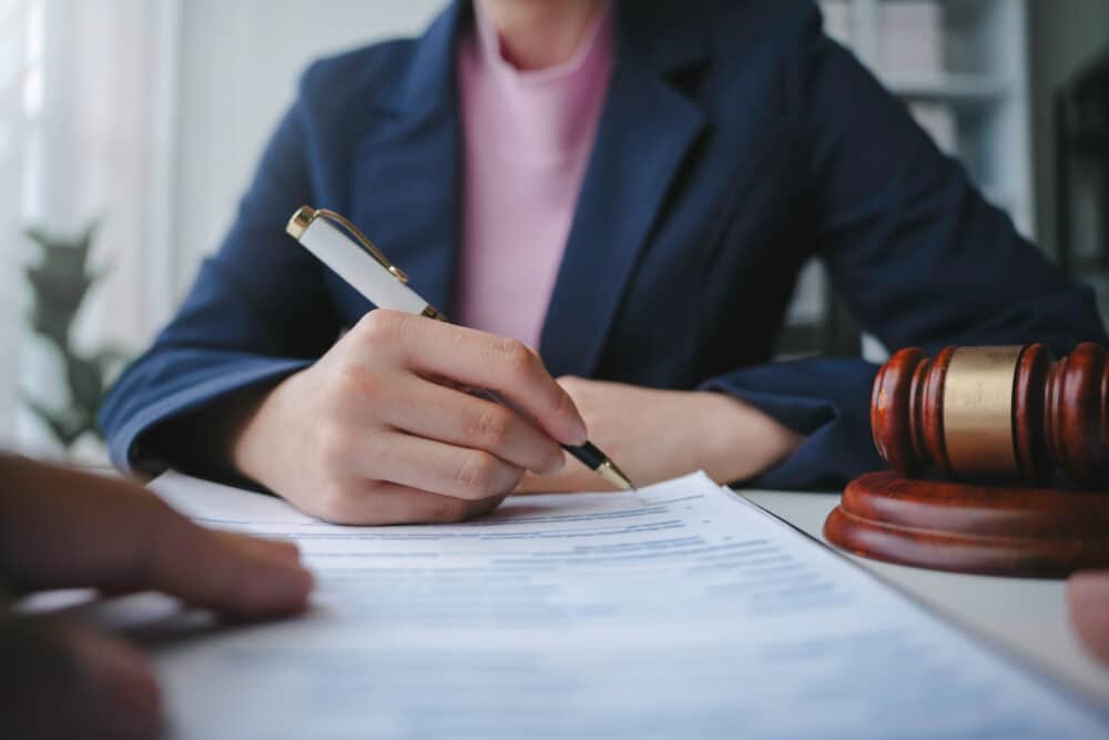 A woman is signing a document. Probate Administration at Wheeler Upham, Attorneys, Grand Rapids, Michigan